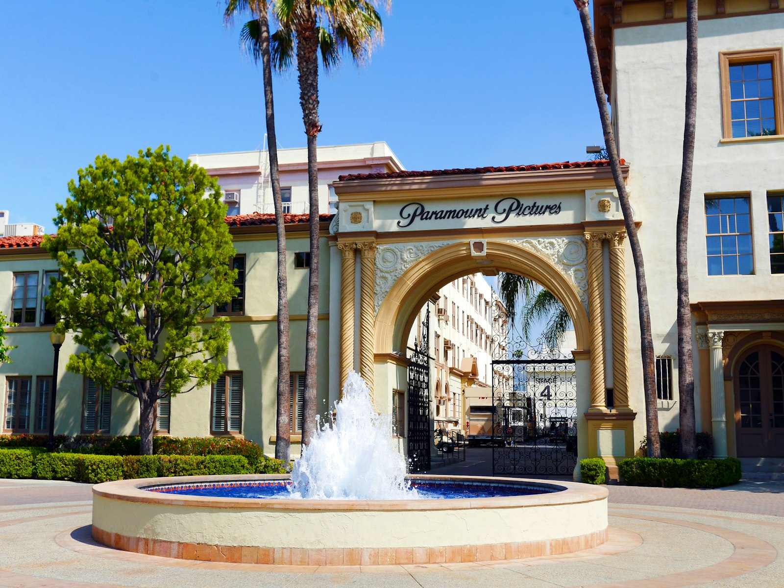 The arched studio gate and fountain at a Hollywood film lot, for a Pulse Report on the Skydance and Warner Bros. Discovery merger